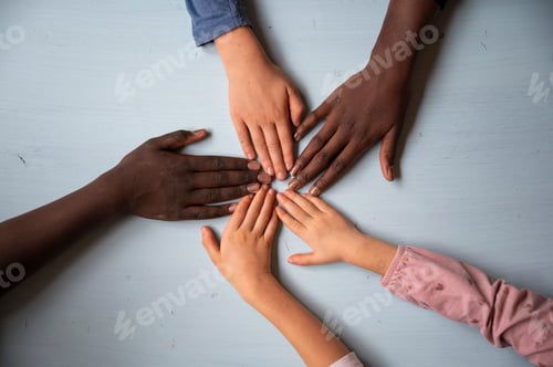 Preview: Top view of five hands of children of mixed races making a star