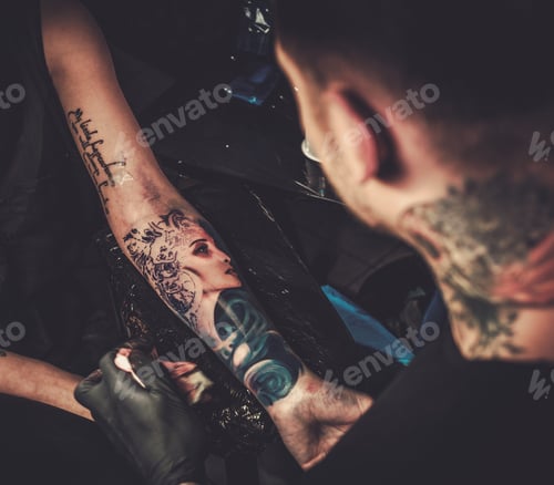 Preview: Professional tattoo artist makes a tattoo on a young girl's hand.
