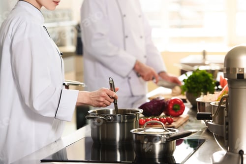 Preview: Professional team of cooks working together on modern kitchen