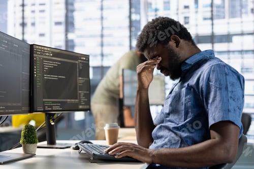 Preview: Exhausted man rubbing eyes, working with machine learning tech