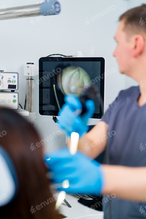 Preview: An ENT doctor performs an endoscopy procedure patient's ear in clinic holding a professional device