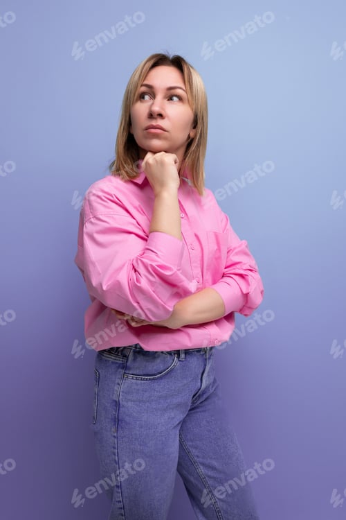 Preview: young pensive blond caucasian secretary woman with flowing hair is dressed in a pink blouse and