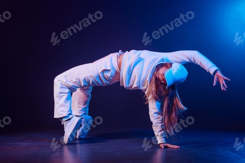 Preview: a girl in light clothes dances on a neon background in smoke, modern dance