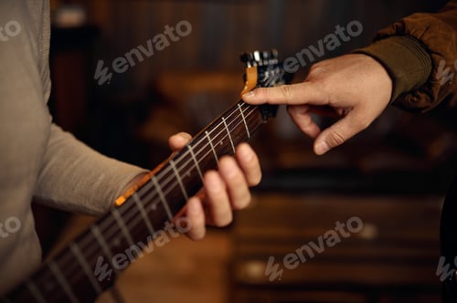 Preview: Closeup hand of male musician playing guitar