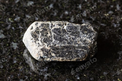Preview: sample of raw augite mineral on black granite
