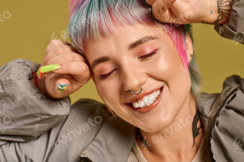 Preview: Young woman with colorful short hair smiling happily in a bright studio