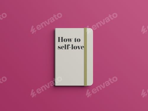 Preview: Top view of a book with "How to self-love" written on a cover against a dark pink background