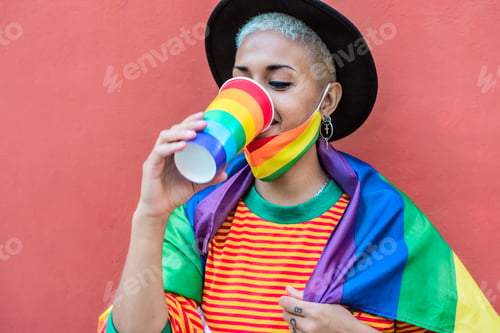 Preview: Young woman drinking cocktail during gay pride parade - LGBT social movement concept