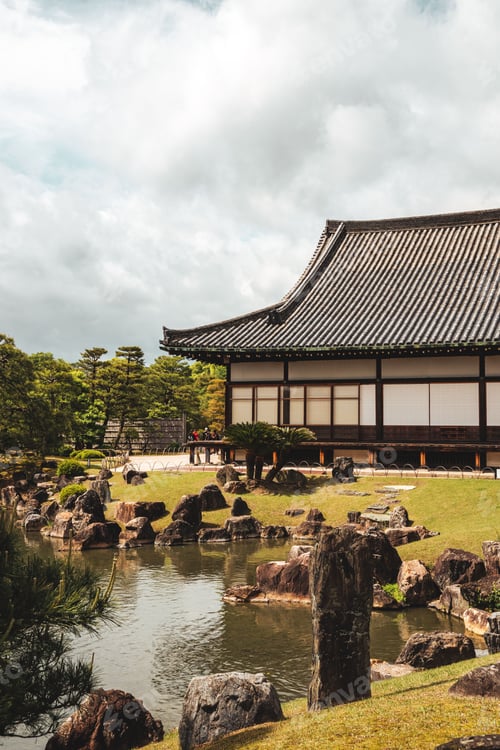 Preview: Scenic view of rocky formations and lush green trees near a pond in a Japanese garden in Kyoto.