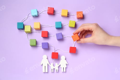 Preview: Woman making family tree with colorful cubes on lilac background, top view