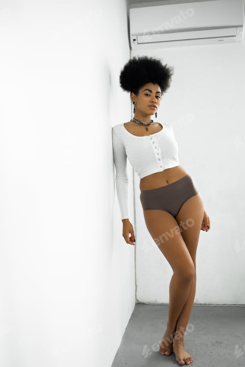 Preview: full length of barefoot african american woman in long sleeve shirt and underwear standing near