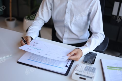 Preview: Businessman working in office reading documents analyze data for project planning.