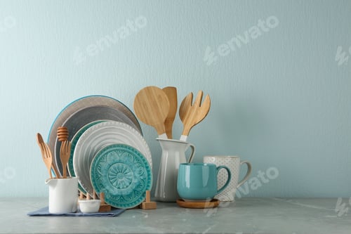 Preview: Set of kitchenware on grey marble table near light wall, space for text. Modern interior design