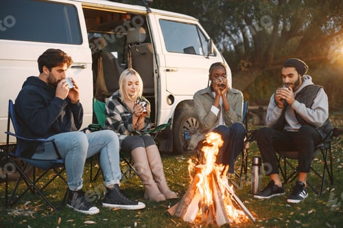 Preview: Multi racial people drink coffee by fireplace