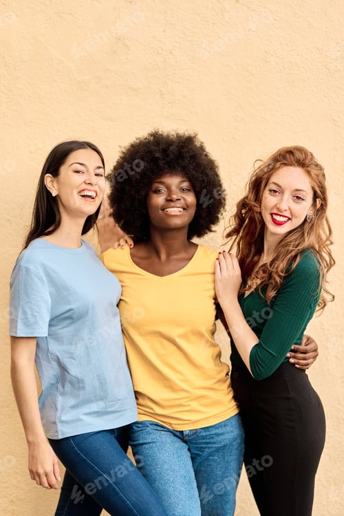 Preview: Vertical portrait of three multiracial friends smiling at camera