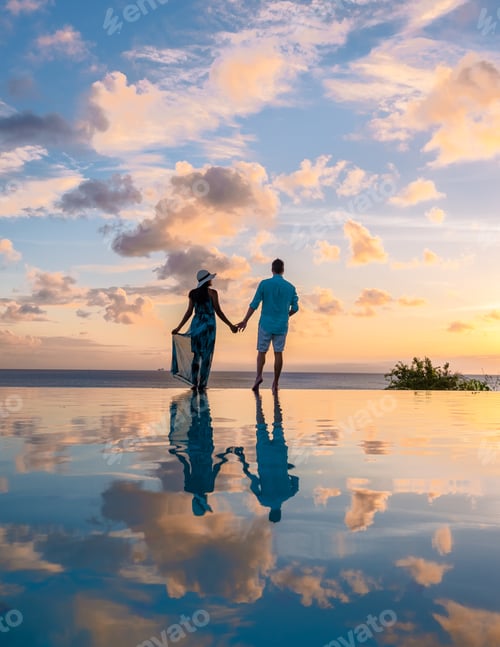 Preview: Young men and women watching sunset with reflection in the infinity pool at Saint Lucia Caribean