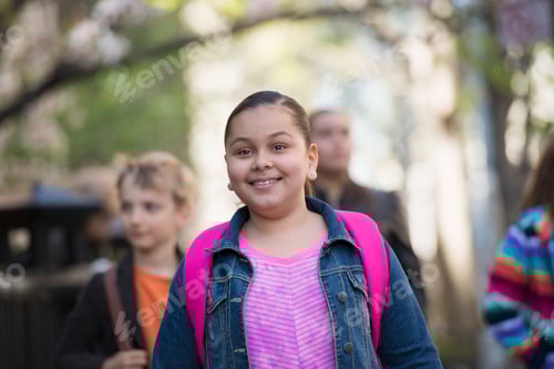 Visualização: Um grupo de crianças na calçada com mochilas escolares ou sacolas de livros.