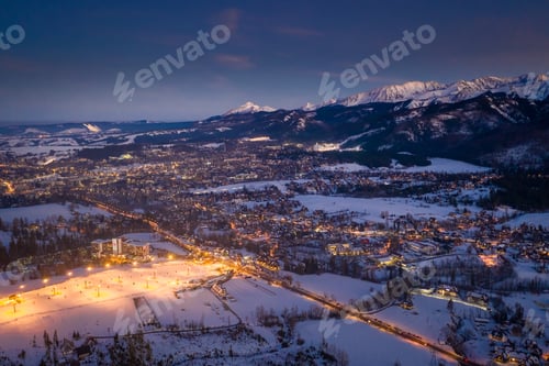 Preview: Breathtaking illuminated Zakopane city after dusk in winter, aerial view