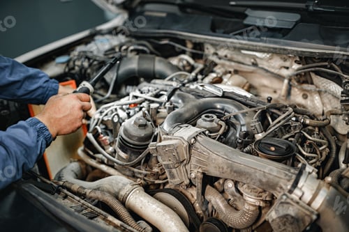 Preview: Auto mechanic man checks car engine under the hood