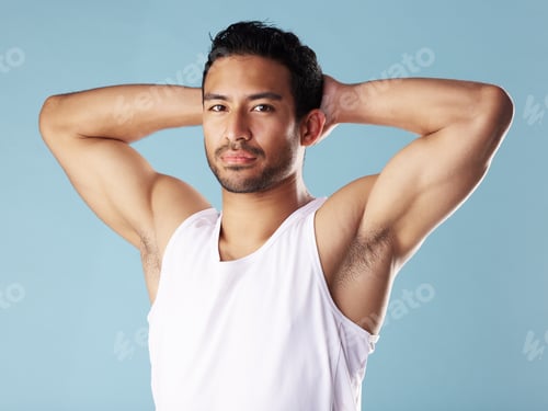 Preview: Handsome young hispanic man posing in studio isolated against a blue background. Mixed race male at