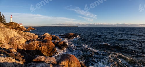 Preview: Panoramic view of a rocky ocean coast during a vibrant sunny sunset