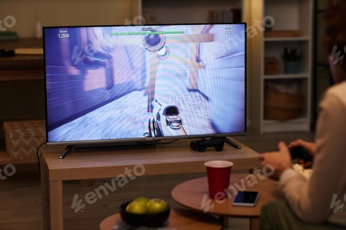 Preview: Man playing videogames on TV with game screen