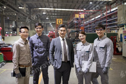 Preview: Confident businessman and engineering team in the factory