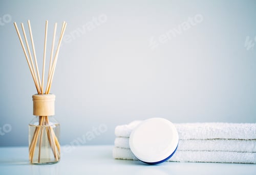 Preview: Spa concept. Moisturizing cream, towels and aroma oil on table in bath room