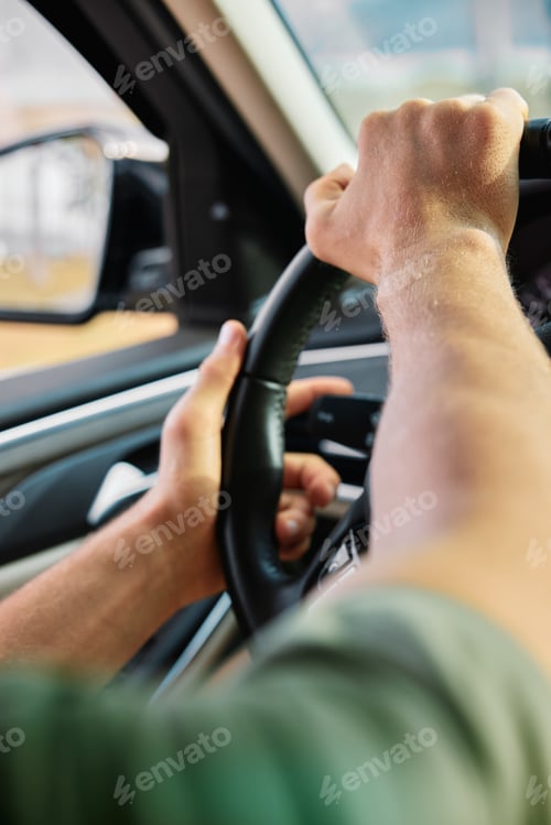 Preview: Close up of hands gripping a steering wheel inside a car