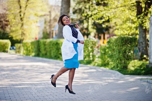 Preview: Smiling Doctor Jumps with Stethoscope in Outdoor Setting