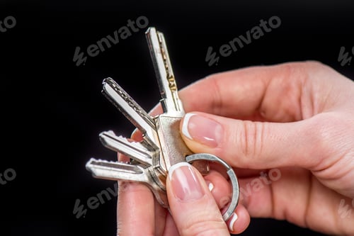 Preview: Close-up partial view of businesswoman holding keys isolated on black