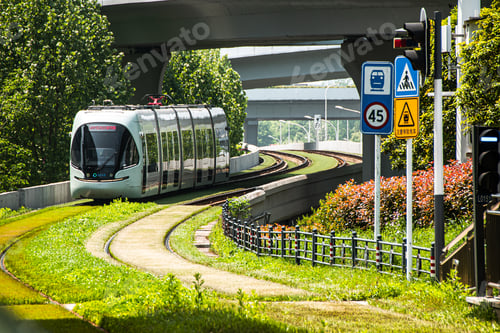 Preview: White train traveling on tracks beside trees and grass