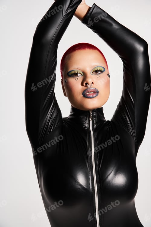 Preview: Bold young woman with pink hair and unique style poses creatively in studio setting