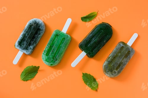 Preview: Refreshing mint popsicles on vibrant orange background for summer coolness