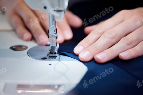Preview: Hands of professional seamstress holding piece of fabric close to sewing needle
