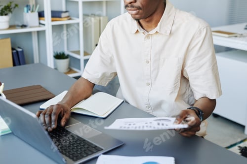 Preview: Unrecognizable Black Man using Computer at Work