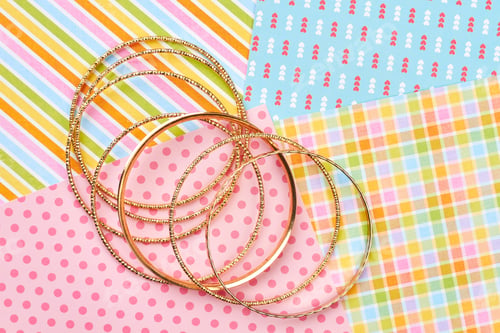 Preview: Set of golden bracelets, colorful background.