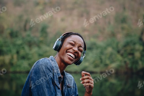 Preview: Woman listening to music outdoors, vivid tone filter
