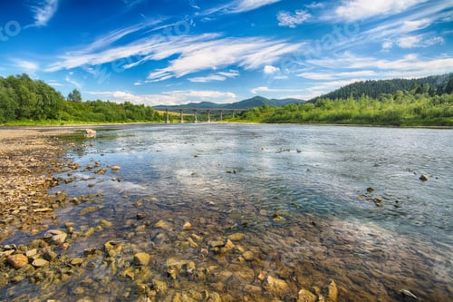 Preview: Mountain river stream of water in the rocks with majestic blue s