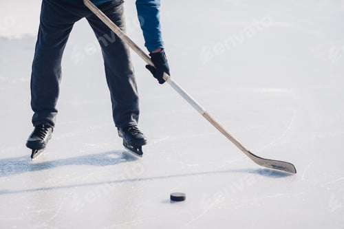 Preview: An elderly man practices ice hockey on a frozen lake in winter.