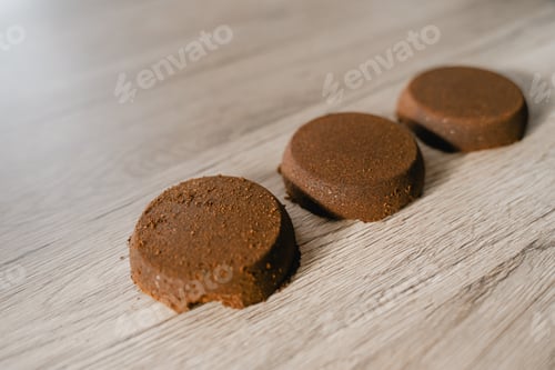 Preview: pressed ground coffee tablets lie on the table