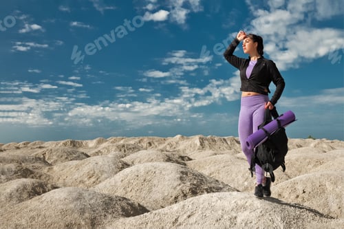 Preview: woman half-face tourist on hill area in sportswear with backpack on sunny day, concept of goal