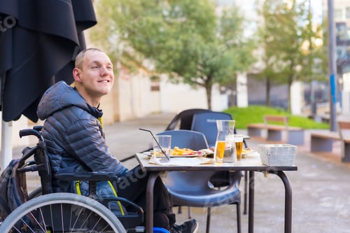 Preview: A disabled person eating on the terrace of a restaurant