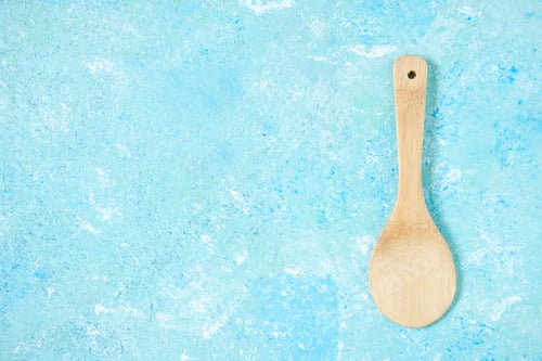 Preview: top view round wooden spoon on blue background with copy space