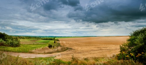 Preview: panorama of the field after the harvest under dark storm clouds, the border of summer and autumn