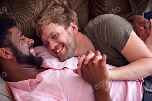 Preview: Loving Male Gay Couple Relaxing Lying On Sofa At Home Hugging