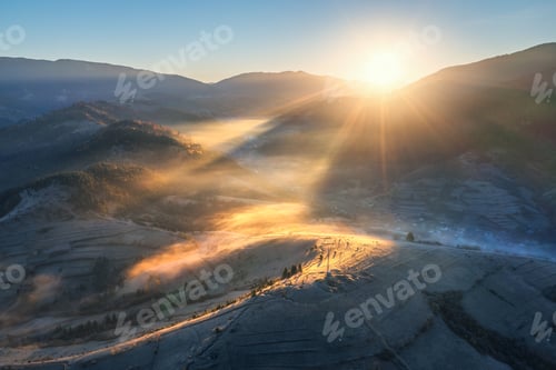 Preview: Aerial view of mountains and hills in low clouds at sunrise