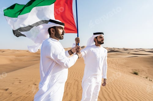 Preview: Two middle-eastern emirati men wearing arab kandura bonding in the desert