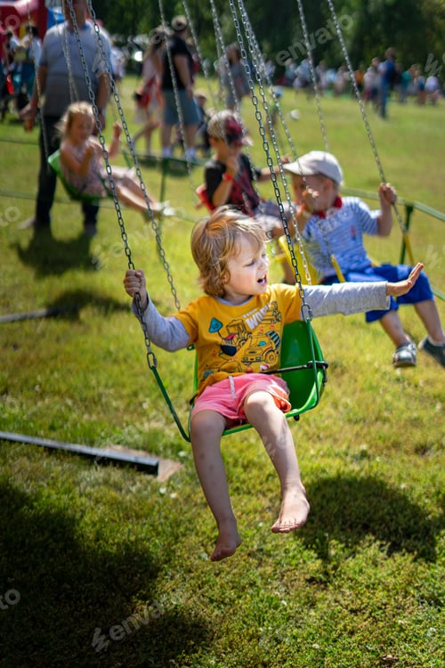 Preview: cute boy on the carousel. Children in the summer on the carousel in the Park