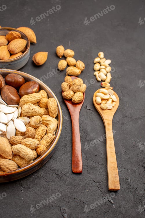 Preview: front view fresh nuts peanuts and other nuts on dark background photo wood many nut